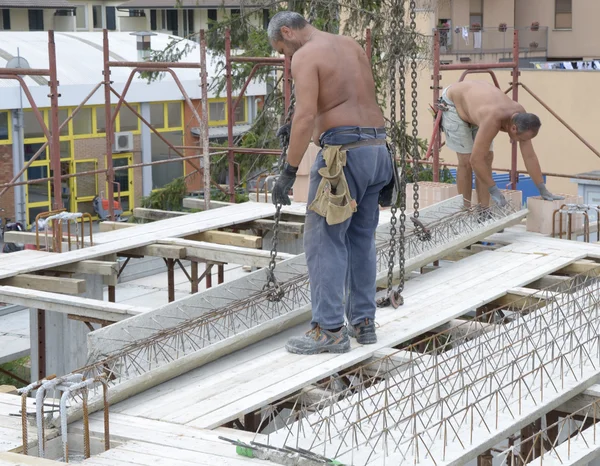 Trabajadores de la construcción colocando las vigas de hormigón — Foto de Stock