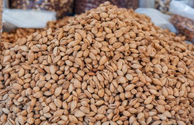 Kabuklarında bol miktarda çiğ badem var. Açık hava pazarında seçici bir odak ile yakalanmışlar. Bu canlı, doğal çekim zengin dokuları ve taze bolluğu vurguluyor, sağlıklı beslenme ve pazar üretimi temaları için mükemmel..