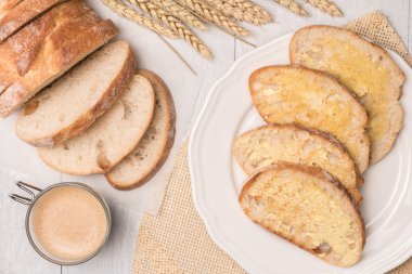 Taze ekmek, ev yapımı tereyağı ve kahve ahşap arka plan üzerinde. 