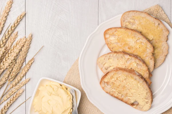 Frisches Brot, Weizenspieß und hausgemachte Butter auf hölzernem Hintergrund — Stockfoto