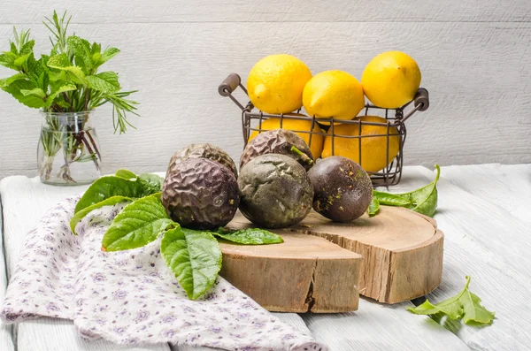 Passionsfrüchte mit Blättern, Zitronen und Kräutern im Glas — Stockfoto