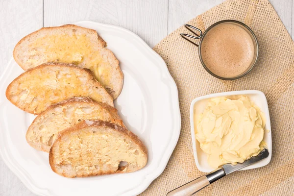 Frisches Brot, hausgemachte Butter und Kaffee auf Holzgrund. — Stockfoto