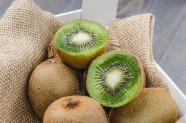 Ahşap arka plan üzerinde içinde taze kivi kutusu.