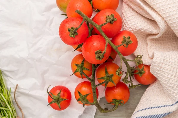 Organic cherry tomatoes with rosemary on wrinkled paper — Stock Photo, Image