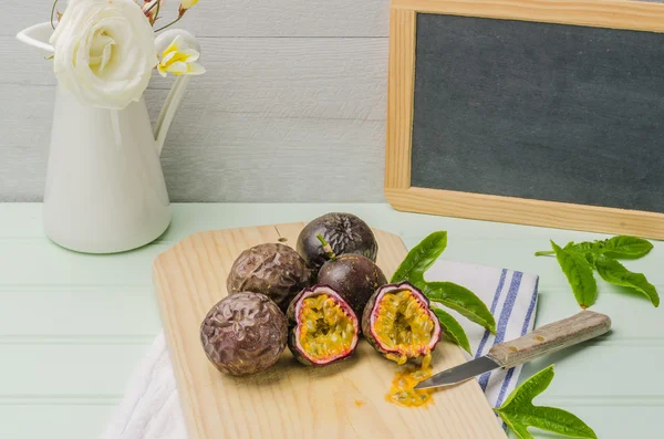 Passionsfrüchte mit Blättern, Messer und weißen Blüten im Glas — Stockfoto