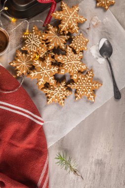 Tezgahta kremalı zencefilli kurabiyeler ve şenlikli ışıklar. Noel kurabiyeleri şekerle süslenmiş kar taneleri. Noel tatili geleneği ve gelişimi