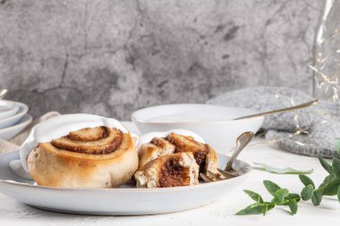 Tarçınlı çörek ya da Noel için kremalı tarçın. Ev yapımı geleneksel kış festivali çörekleri. Beyaz arka planda kahvaltı için hamur işi.