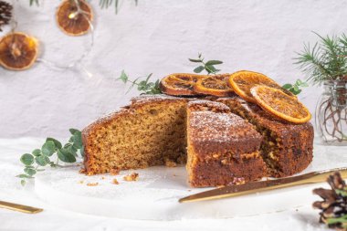 Noel portakalı ve baharatlı kek. Mutfak tezgahında kurutulmuş portakallarla süslenmiş.