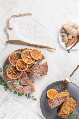 Noel portakalı ve baharatlı kek. Mutfak tezgahında kurutulmuş portakallarla süslenmiş.