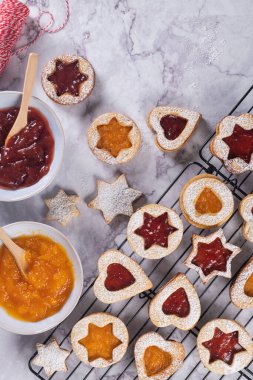 Lezzetli ev yapımı Noel kurabiyeleri. Geleneksel Avusturya Noel kurabiyeleri - kırmızı ahududu reçeli ve balkabağı reçeli ile dolu Linzer bisküvileri. Şenlik dekorasyonu. Ev yapımı fırın. Düz yatış, üst görünüm