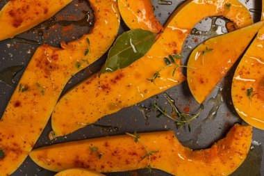 Fırında pişirmek için hazırlanmış bir sürü parlak balkabağı dilimi..