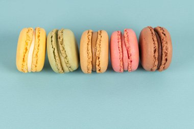 Turkuaz arka planda pasta ya da badem kurabiyeleri, pastel renkler, eski kartlar, üst görünüm.