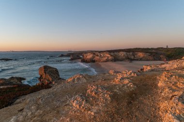 Alentejo, Portekiz 'de Porto Covo' da kayalıklarla plajda gün batımı.