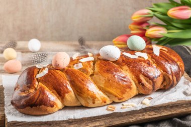 Portekiz geleneksel paskalya pastası. Paskalya masasında yumurtalı folar. Çiçekli laleler, renkli boyanmış yumurtalar ve tüyler.