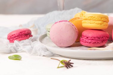 Renkli Fransız kurabiyeleri. Beyaz masa arkaplanında yasemin çiçekli kurabiyeler. Seçici odak