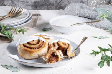 Tarçınlı çörek ya da Noel için kremalı tarçın. Ev yapımı geleneksel kış festivali çörekleri. Beyaz arka planda kahvaltı için hamur işi.