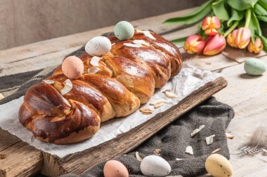Portekiz geleneksel paskalya pastası. Paskalya masasında yumurtalı folar. Çiçekli laleler, renkli boyanmış yumurtalar ve tüyler.