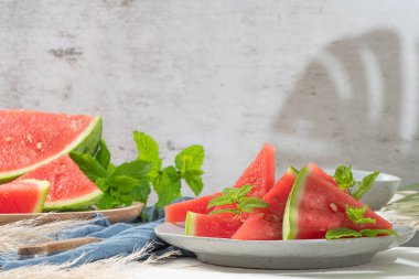 Olgun karpuz bileşimi ve mutfak masasında taze nane. Olgun yaz karpuzu. Sulu karpuz. Masadaki mevsimlik meyve kavramı