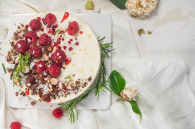 Mutfakta ahududu, çikolata, fındık ve biberiye yapraklı cheesecake.