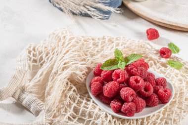 Tahta masadaki bir tabakta olgun ahududular. Kapat, üst görünüm, yüksek çözünürlüklü ürün