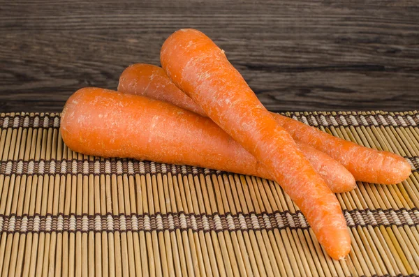 Морковь на соломенном плацемате — стоковое фото