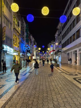 Porto, Portekiz - 9 Aralık 2023. Santa Catarina caddesinin gece manzarası. Yöre sakinleri ve ziyaretçiler Noel ışıklarını ve belediye binasının önündeki büyük Noel ağacını görmek için caddelerde yürüyorlar.
