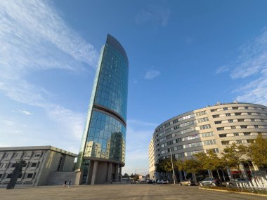 Maia, Portekiz - 16 Ekim 2025. Portekiz 'in Maia kentindeki mimari kontrastta, eğri büğrü, teraslı beton bir binanın yanında şık Torre do Lidador yer alıyor.