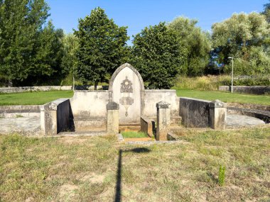 Portekiz 'in Ovar kentindeki tarihi Fonte dos Pelames, yeşil parklarla çevrili geleneksel bir taş çeşmesi.