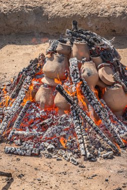 AMARANTE, PORTUGAL - 30 HAZİRAN 2022: Gondar 'ın kara kil pişirme işlemi sırasında kil parçaları üst üste yığılmış şenlik ateşi toprağı ile kaplama aşaması