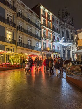 Porto, Portekiz - 9 Aralık 2023. Porto 'daki Rua das Flores ya da Flores caddelerinin Noel süslemeleriyle süslendiği gece sahnesi. Yöre sakinleri ve ziyaretçiler Noel ışıklarını görmek için sokaklarda yürüyorlar.