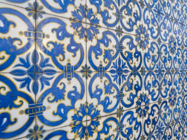 Geleneksel Portekiz azulejo fayansları üzerinde sarı aksanlı canlı mavi ve beyaz geometrik ve Barok tarzı çiçek desenleri tekrarlanıyor