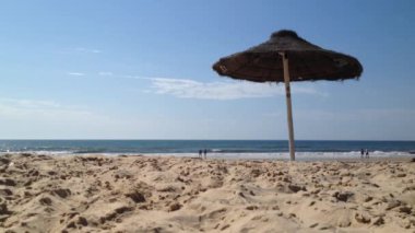 Praia Verde Castro Marim, Algarve, Portekiz görünümünü. Bir plajda saman şemsiye.