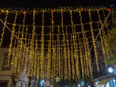 Espinho, Portekiz - 6 Aralık 2025. Espinho Şehri, Portekiz Noel Işıkları Şenlikli LED ışıklardan oluşan Arch Altın Şelalesi Espinho Portekiz 'de bir caddenin üzerinde pırıl pırıl bir kemer oluşturarak tatil sezonunun sihrini yansıtıyor.