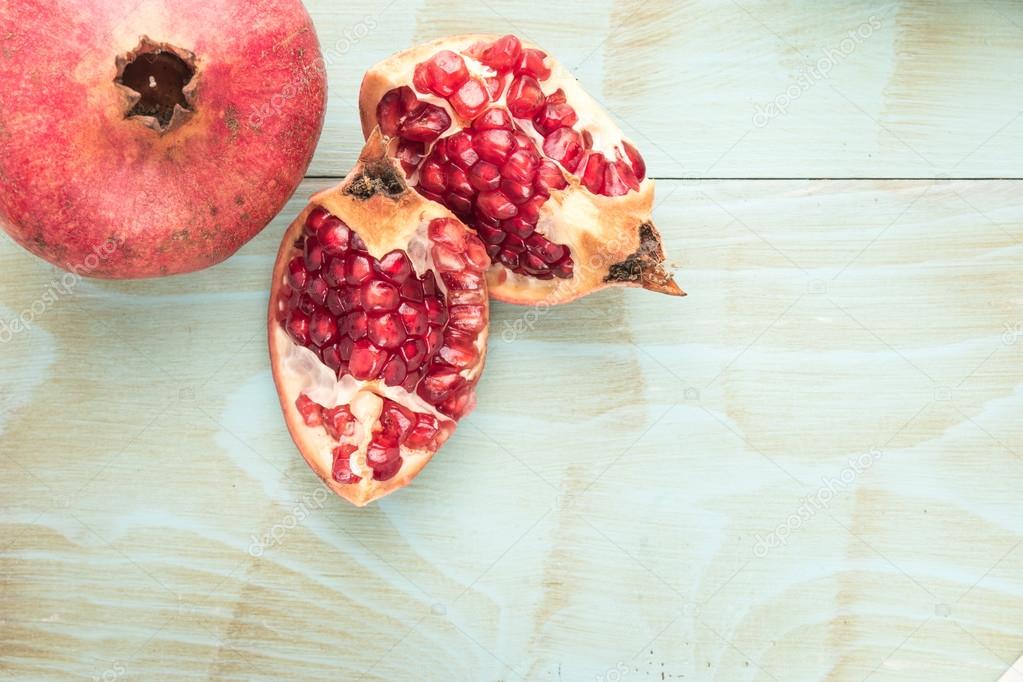 Pomegranates over grunge wooden background