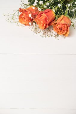 Turuncu gül ve gypsophila ahşap masa üzerinde bir buket. Kopya alanı