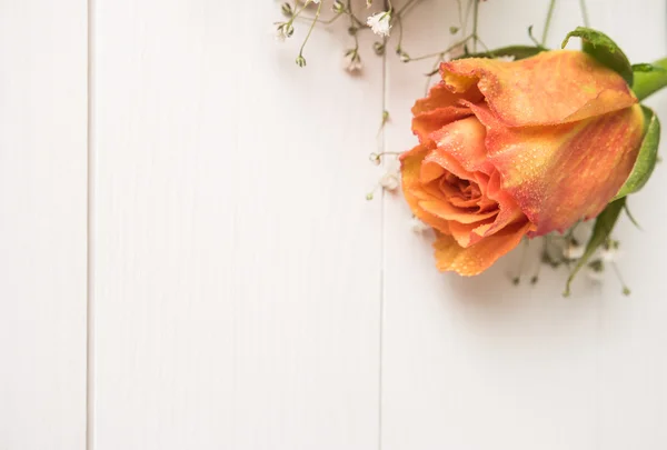 Ein Strauß orangefarbener Rosen und Zigeunerblumen auf einem Holztisch. Kopierraum — Stockfoto