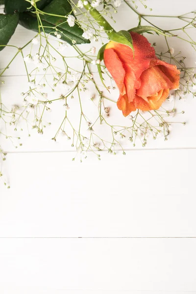 Ein Strauß orangefarbener Rosen und Zigeunerblumen auf einem Holztisch. Kopierraum — Stockfoto