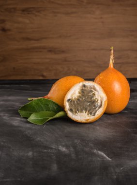 Taze granadillas barut yaprakları ile üzerinde. Rustik tahta üzerinde granadillas