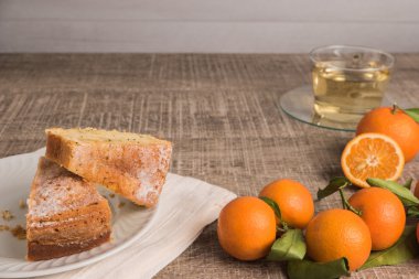 Pudra şekeri Tepesi ve papatya çayı fincan ile clementine pasta dilimleri