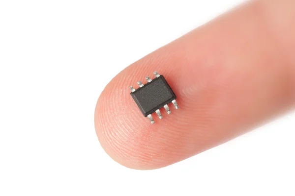 Microchip pequeño en el dedo humano — Foto de Stock