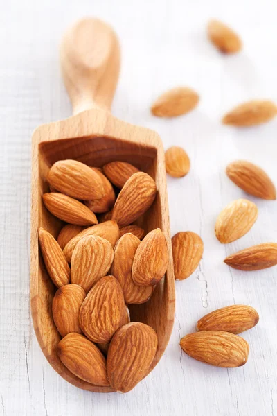 Wooden scoop of almond nuts — Stock Photo, Image