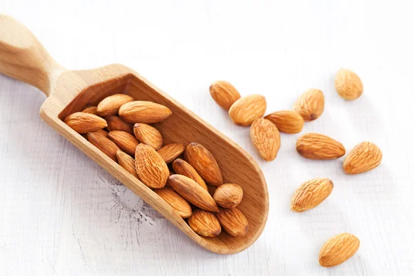 Wooden scoop of almond nuts — Stock Photo, Image
