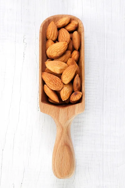 Деревянный совок миндальных орехов — стоковое фото
