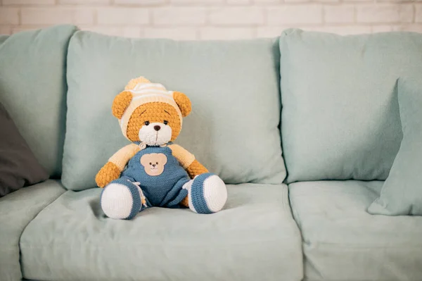 Orso giocattolo lavorato a maglia sul divano — Foto Stock