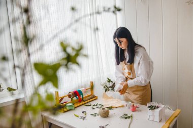 Çiçekçisinin kırsal tarzında bir buket oluşturma sürecinde önlüklü esmer bir kadın. Yüksek kalite fotoğraf