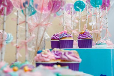 Leylak kekleri ve uzun lolipoplar. Mavi bir stantta kurdeleli. Yüksek kalite fotoğraf