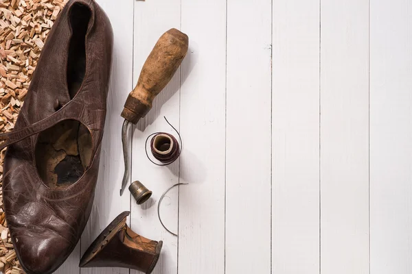 Старая обувь и инструменты для восстановления. Фон Лицензионные Стоковые Изображения