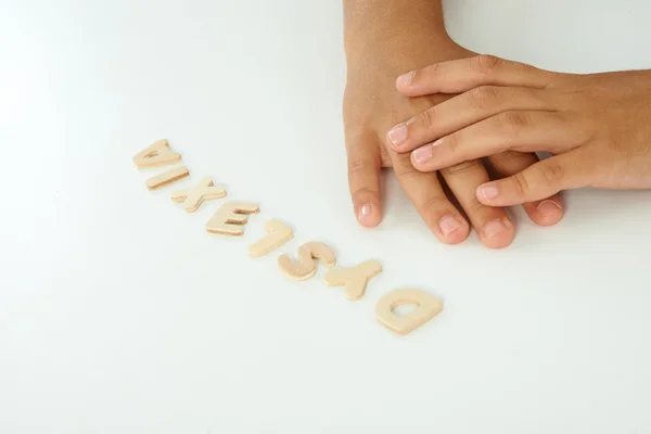 Mãos de uma menina formam a palavra dislexia com letras de madeira — Fotografia de Stock