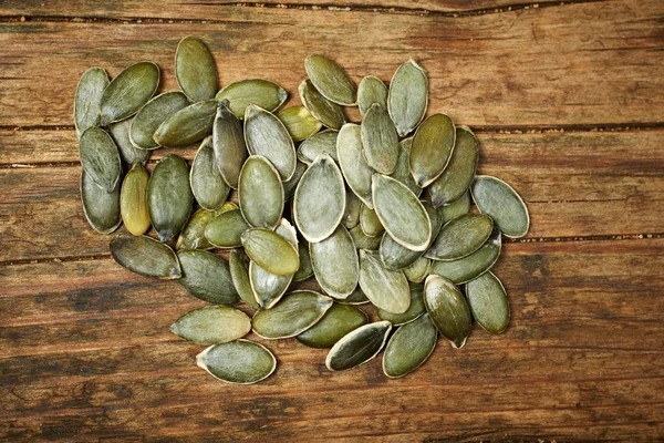 Pumpkin seeds close up on wooden table — Stock Photo, Image