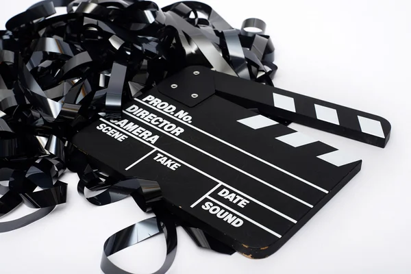 Movie clapper board with video tape on white background — Stock Photo, Image